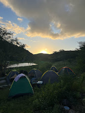 Acampamento à beira do rio ao entardecer